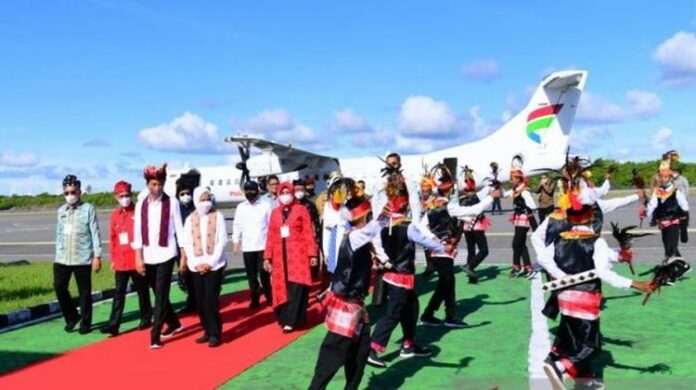 Presiden Jokowi dan Ibu Negara Iriana disambut pertunjukan tari Sajo Moane dan mendapat kain tenun khas Wakatobi saat tiba di Bandara Matahora, Kabupaten Wakatobi, Kamis (9/6/2022). Foto: Suara.com.