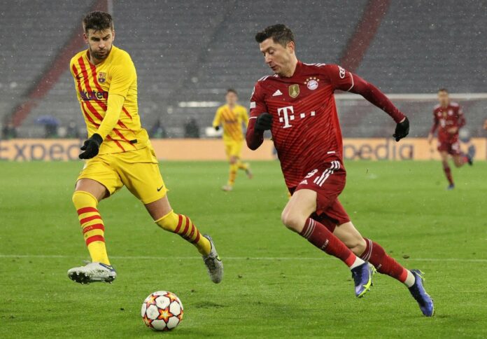 Bomber Bayern Munchen Robert Lewandowski (kanan) berduel dengan bek Barcelona, Gerard Pique. Foto: Twitter/FCBayern